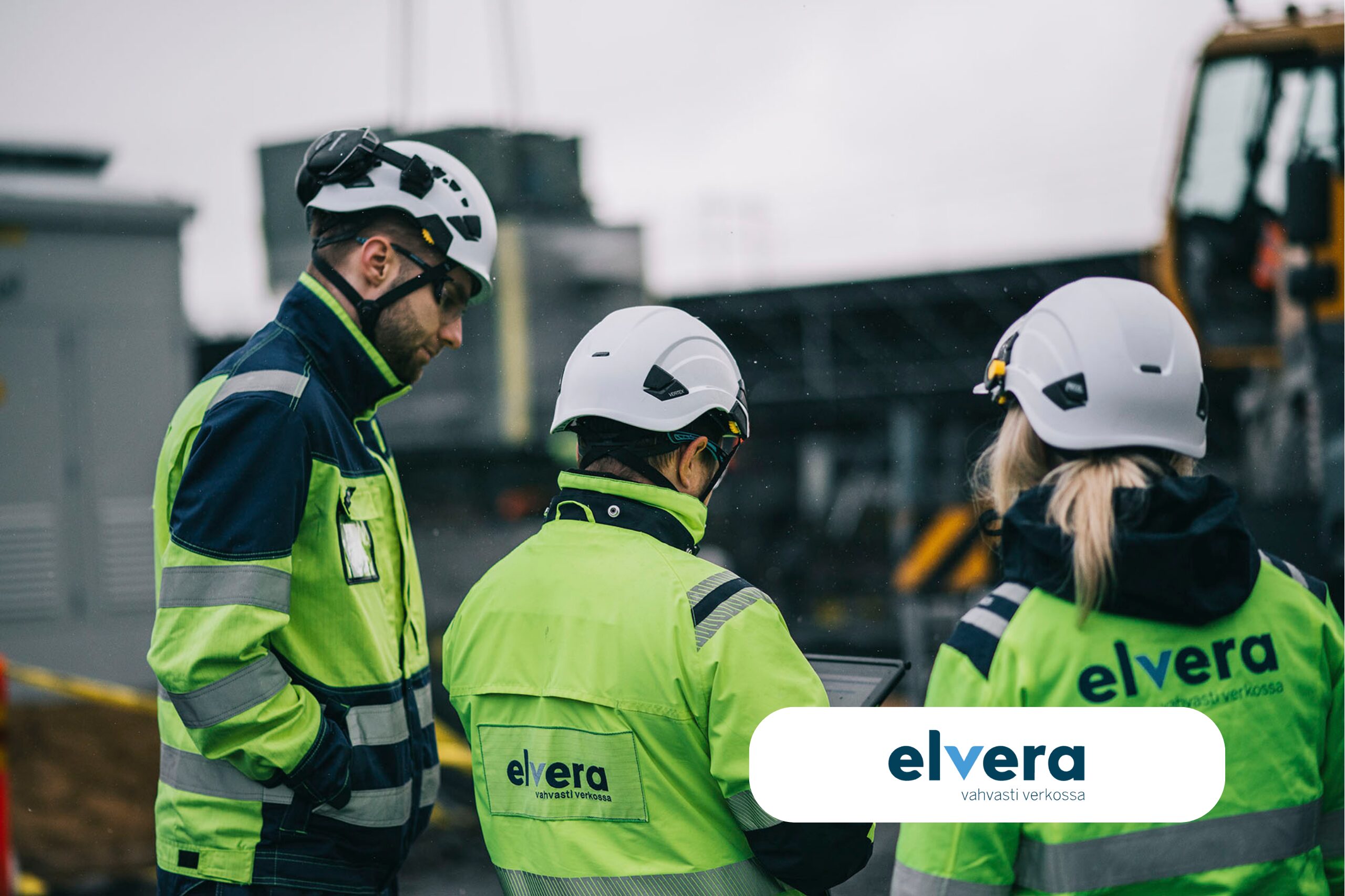 Kuvassa kolme kypäräpäistä työntekijää työmaalla