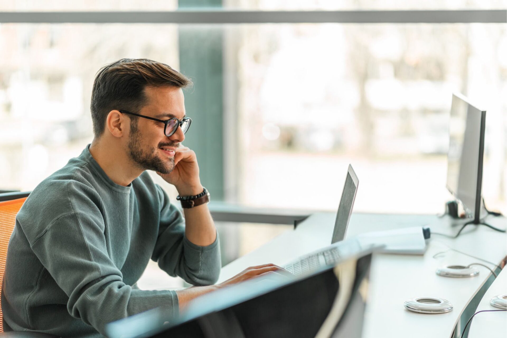 mies tietokoneen ääressä toimistolla